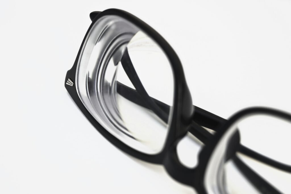 Modern black frame eyeglasses close-up on white surface, showcasing stylish eyewear design.
